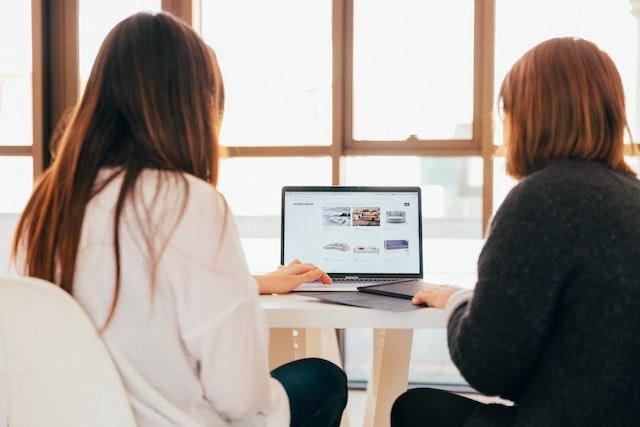 brand manager working with a colleague on a laptop